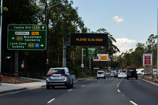 please slow down sign on overhead digital signage on road to castle hill A28