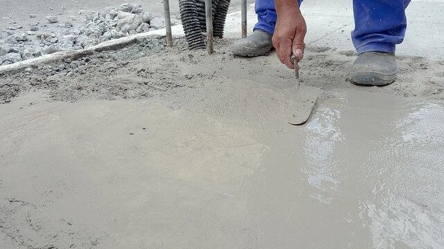 A bricklayer repairing a sidewalk with cement in the city of Sao Paulo.