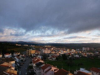 Obraz premium Winter sunrise over Bragança in northern Portugal with snow covered mountains in the background, capturing the warm morning light over the city landscape.