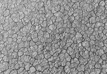 Black and white top view of cracked dry soil texture background,High angle monochrome shot of parched earth with deep cracks. An abstract natural pattern representing drought, climate change, © banjongseal324