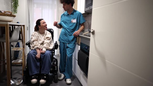 Kind male caregiver helping a woman with cerebral palsy sitting in a motorized wheelchair in her adapted apartment kitchen, demonstrating supportive and empathetic home healthcare service