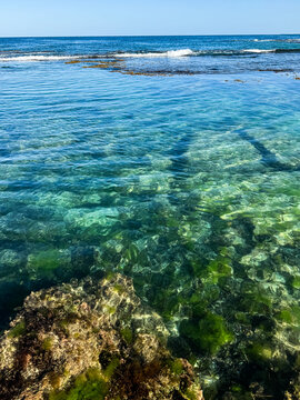 Ocean scape of Clear green blue ocean waters in reef rock pool and small lapping waves