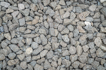Closeup texture of gray gravel stones forming a rough natural surface, ideal for construction, background, and industrial design concepts.