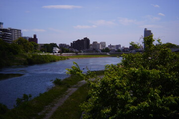 ​​Cityscape across a river on a sunny day with blue sky