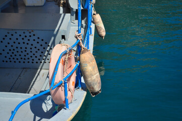 Maritime travel concept: boat safety gear and blue railings over emerald sea waves