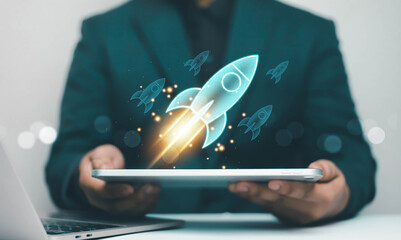 Startup rocket launch hologram rising from tablet in businessman hands, symbolizing business growth, innovation strategy, digital transformation, project success and technology development concept. © ภัทรชัย รัตนชัยวงค์