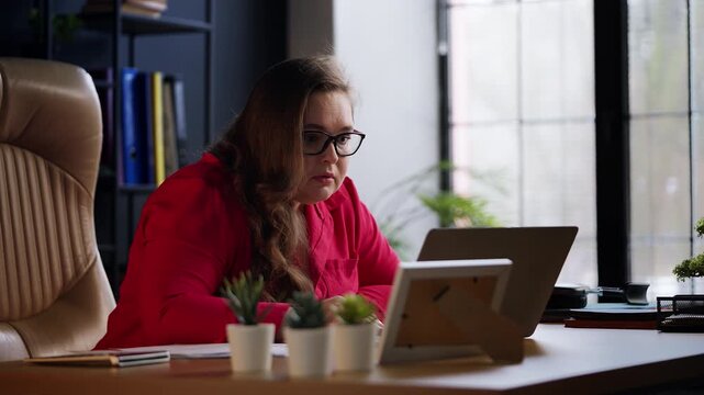 Female sales manager feeling unhappy after reading negative feedback on laptop
