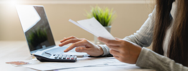 Financial owe, hand of asian woman sitting, holding credit card, stressed by calculate expense from...
