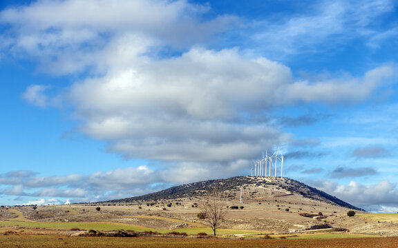 Wind turbines on a hill in an empty landscape of Soria province, Central Spain, on a partly overcast winter day