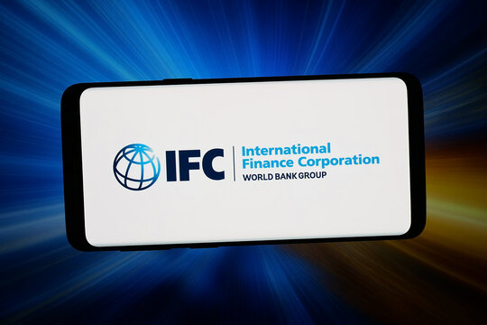 Stuttgart, Germany - 02-25-2026: In this photo illustration, the logo of International Finance Corporation (IFC) is displayed on a smartphone in front of abstract background on computer screen.