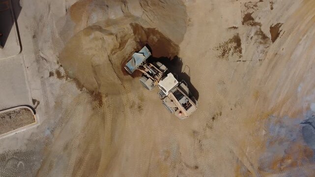 Heavy machinery front loader moving sand at construction site