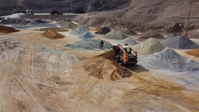 Skid steer loader moving earth at construction site