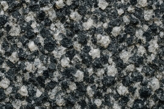 Dark gray granite background with black mineral patches and quartz speckles