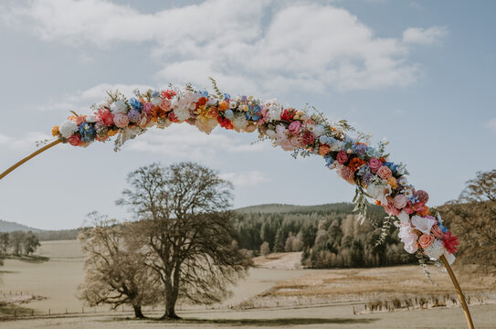 Close up of a wfloral edding archway with blue sky in the background for an outdoor wedding