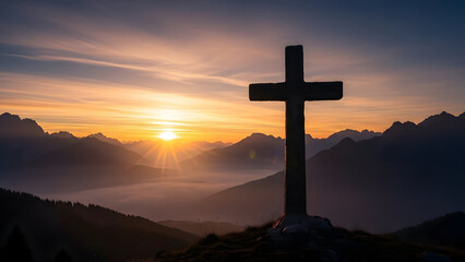 Cross on a hill at sunset with mountains