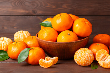 Fresh, ripe, juicy tangerines on the table. Whole and halved tangerines, clementines with green leaves. Citrus fruits. Tangerine or clementine. Fresh oranges. Vitamin C. Natural vitamin. Orange. Space
