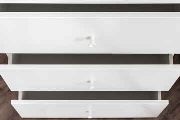 White dresser with open drawers, home storage concept