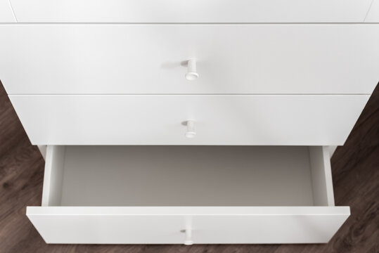 White cabinet with single open drawer in minimal interior