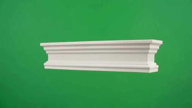 A white decorative Crown molding section with intricate detailing rotates slowly on a green screen.
