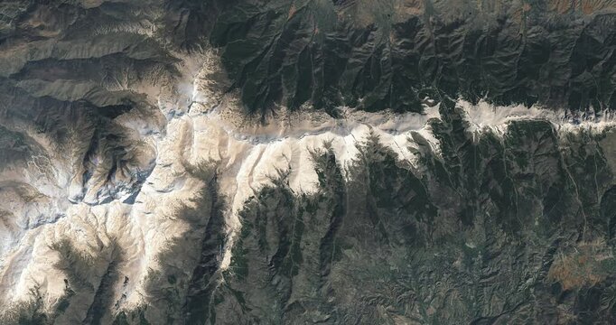 Top shot on mountain ridge covered with snow. Camera is zooming out, rotating counterclockwise. Animation based on image by NASA