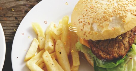 Displaying white plate with sesame-seed burger, peppered thick-cut fries on rustic table, overlays © vectorfusionart