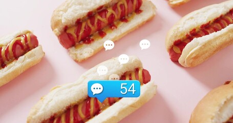 Showing central hotdog sitting in bun on pink backdrop, with blue chat bubble 54, speech icons © vectorfusionart