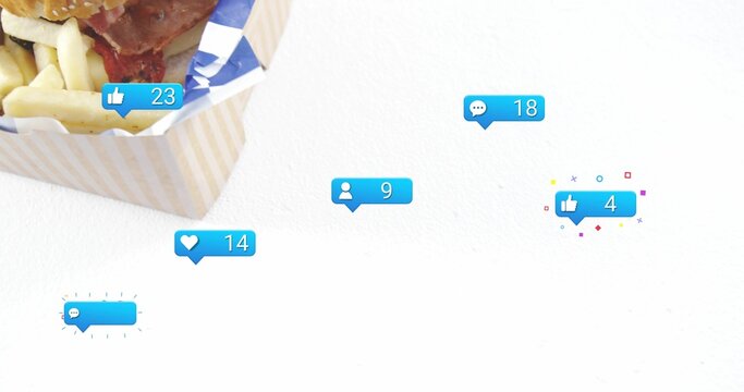 Showing takeout box holding sesame burger and fries on white studio, with blue bubbles, copy space