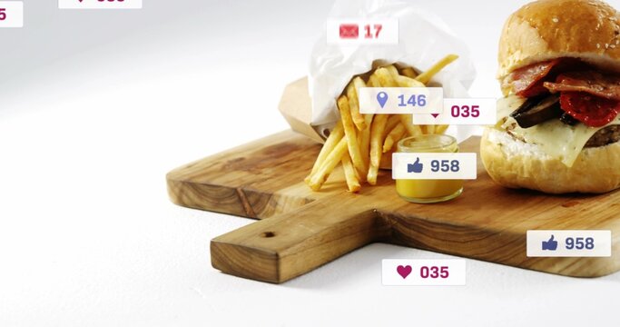 Showing sesame burger, paper fries on wooden board with handle in studio, sauce jar, social icons