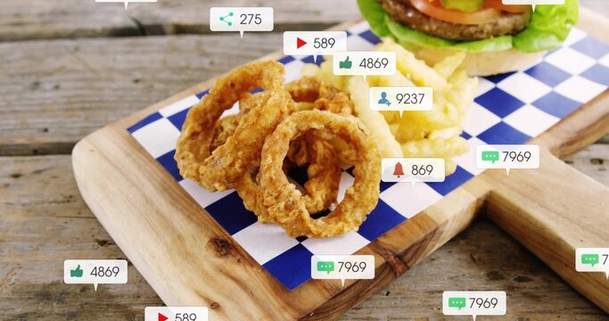 Showing stack of crispy onion rings resting on blue-white paper on wooden board, with social badges