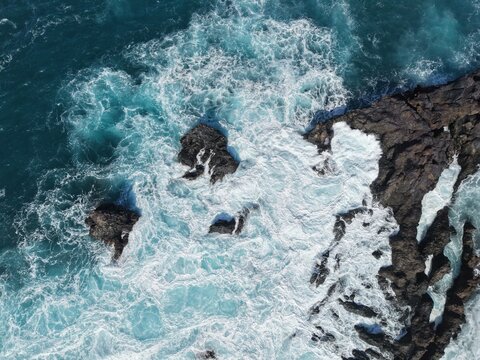 Overhead birds eye drone aerial view  waves breaking over volcanic rocks Tenerife Spain