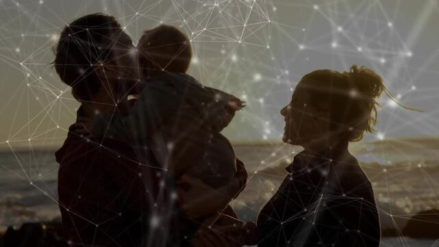 Father lifting infant to mother on shore at sunset, kissing to bond under tech overlay shifting