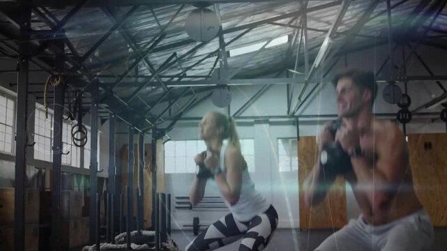 Training pair starting set doing kettlebell goblet squats in fitness gym syncing reps for fitness