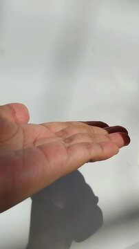 Pouring soap into hands. Vertical view with natural sunlight.