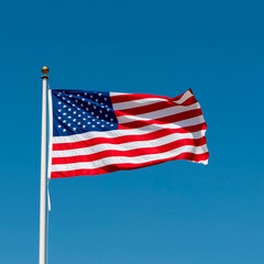 United states flag waving against a clear blue sky