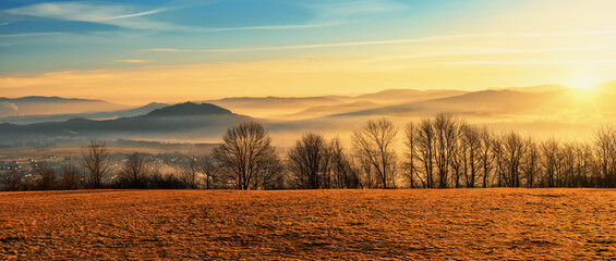 mglisty poranek nad wiejskim krajobrazem z rozległą górską panoramą © piotr