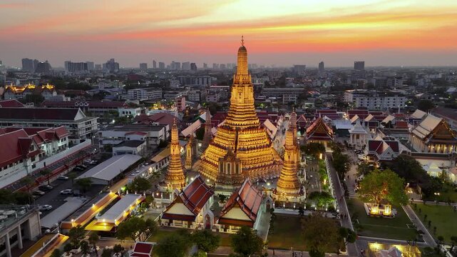 
Aerial drone view of the famous Wat Arun temple also known as the Temple of Dawn, stands tall by the river Chao Phraya at night in Bangkok reflects the vibrant hues of the sunset against the cityscap