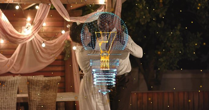 Dancing couple dipping and kissing on backyard deck wearing light dress and shirt showing holo bulb