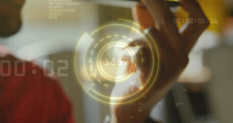 Holding smartphone, man wearing red shirt listening at home office with HUD graphics