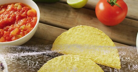 Showing two folded yellow corn tortillas lying on wooden table with salsa tomato lime data overlay © vectorfusionart