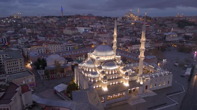 Aerial drone view of Istanbul historic Golden Horn, showing the Eminonu New Mosque or Yeni Cami, Galata Bridge, and Bosphorus at sunrise or sunset. Topkapi Palace and Hagia Sophia in the distance.