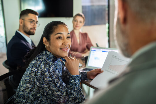 Diverse coworkers discussing growth report in office meeting