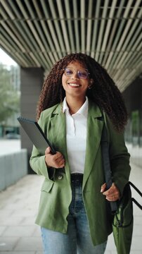 Confident African American business woman walking in office. Portrait of smiling female executive enjoying successful corporate career