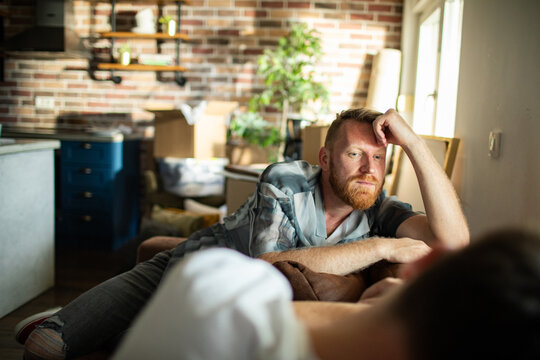 Pensive man lying on sofa in home living room