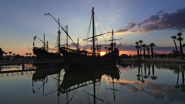 Historic replicas of the Pinta, Nina, and Santa Maria caravels at Muelle de las Carabelas, Huelva, Spain, during a colorful sunset. Ideal for travel and history content