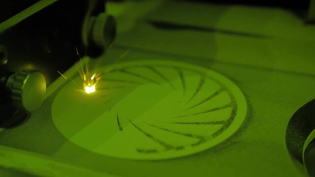 Close-up of a 3D printer laser sintering metal powder to create a circular component.