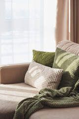 Fototapeta premium Textured Pillows and Blanket on Sofa. Cozy Spring Home Interior with Natural Light