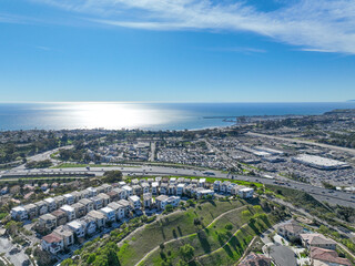 Aerial view over San Juan Capistrano, California, featuring the historic mission, library, sports courts, and an Amtrak train pulling into the downtown station. High quality 4k footage