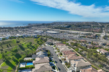 Aerial view over San Juan Capistrano, California, featuring the historic mission, library, sports courts, and an Amtrak train pulling into the downtown station. High quality 4k footage