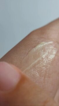 Apply the yellow cream evenly. Cover palms with beauty cream. Vertical shot video.
