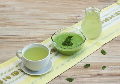 A cup of fresh tea and smoothie from Chickweed, lat. Stellaria media on a table. Traditional herb tea rich in minerals.